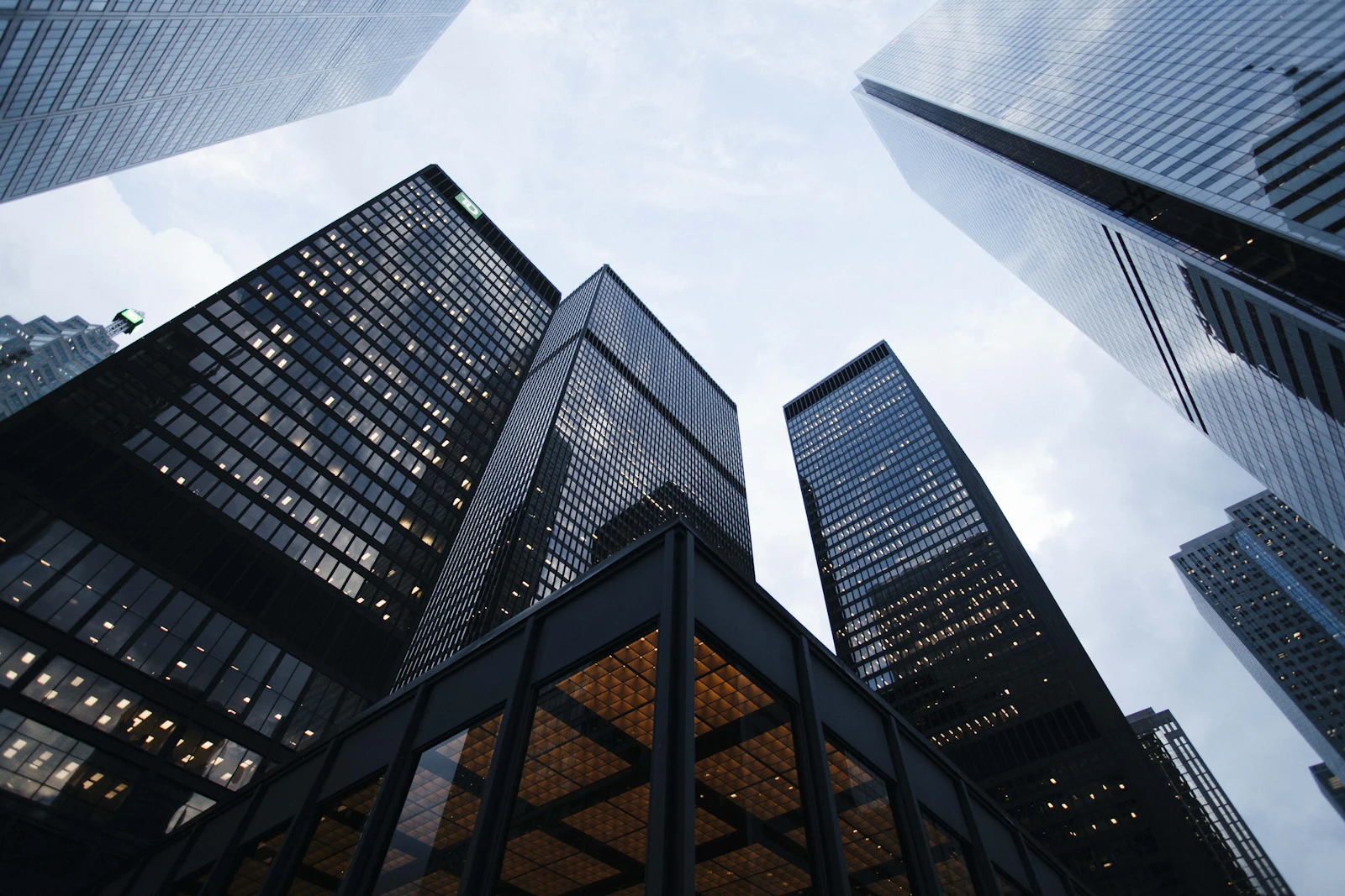 Looking up at glass office towers against a pale sky